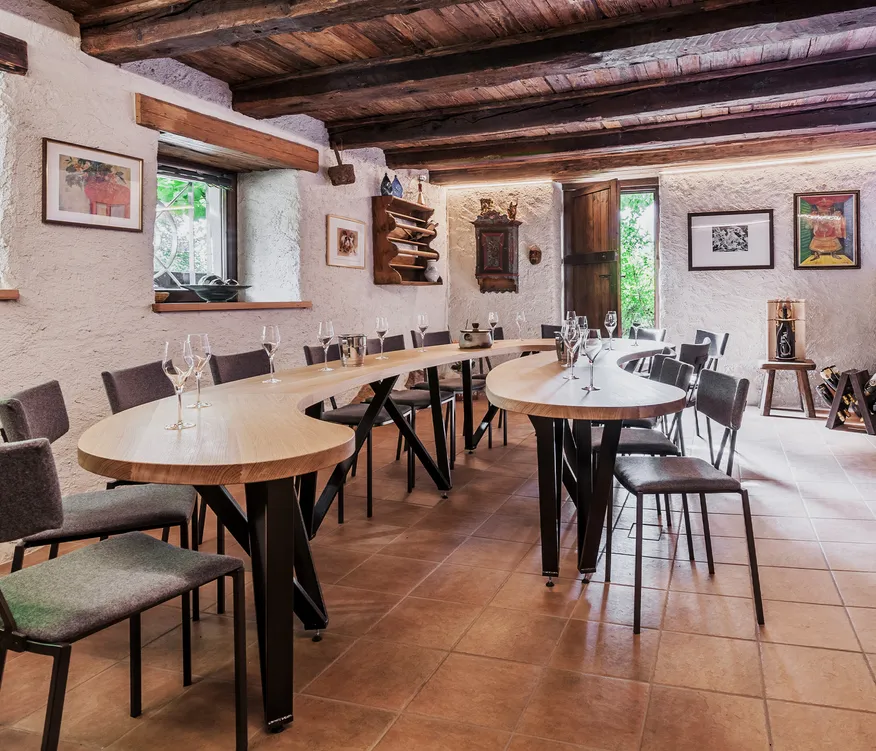 Verkostungsraum mit gewölbter Holzbalkendecke, S-förmigem Eichentisch, gepolsterten Stühlen und Sektgläsern, Mölten